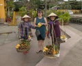 Korean tourist with classic Vietnamese street vendors selling fruit in Hoi An, Vietnam