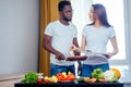 Korean woman wearimg white cotton t-shirt with her african american boyfriend cooking in fry pan bresksast Royalty Free Stock Photo