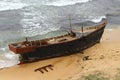 Korean wooden fishing boat wrecking on sandy beach. Big storm waves hitting the boat. Drama of poor north korean fishermen.