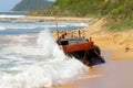 Korean wooden fishing boat wrecking on sandy beach. Big storm waves hitting the boat. Drama of poor north korean fishermen.