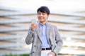 Korean Young Business Man Using Voice Search Holding Cellphone Outdoors