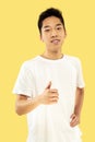 Korean young man`s half-length portrait on yellow background Royalty Free Stock Photo