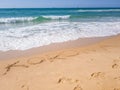 Korona word handwritten in sand on sunny beach with sun sky sea background. The text on the sand, the Korona, against the