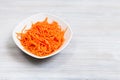 Koryo-saram spicy carrots in bowl on gray table