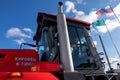 Kostanay, Kazakhstan, 2019-10-23, Cabin of a red tractor of the Kirovets K-730 and flags against the sky with clouds. The concept