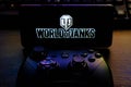 Kostanay, Kazakhstan, February 12, 2020.Joystick and mobile phone with the logo of the popular game World of Tanks, from Wargaming