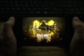 Kostanay, Kazakhstan, November 04, 2021.A man holds a mobile phone with a screensaver of the popular Call of Duty game