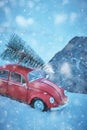 Kostanay, Kazakhstan 2022. Red Volkswagen beetle in snowy weather with spruce on roof, stuck in snow Royalty Free Stock Photo