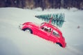 Kostanay, Kazakhstan 2022.Red Volkswagen beetle with spruce on roof, against background white snow Royalty Free Stock Photo