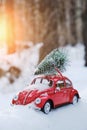 Kostanay, Kazakhstan 2022.Red Volkswagen beetle with a spruce on roof in a winter, snow covered pine forest Royalty Free Stock Photo
