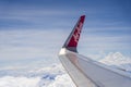 Wing of airplane AirAsia company and sky with clouds, view from flying airplane through window near Kota Kinabalu, island Borneo,