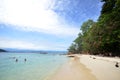 Tourists enjoy white sand beach of Sapi island in Sabah