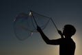 Silhouette boy playing with a bubble wand on the beach Royalty Free Stock Photo