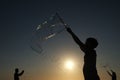 Silhouette boy playing with a bubble wand on the beach Royalty Free Stock Photo