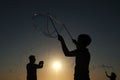 Silhouette boy playing with a bubble wand on the beach Royalty Free Stock Photo