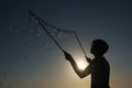 Silhouette boy playing with a bubble wand on the beach Royalty Free Stock Photo