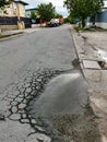 Big pothole on asphalt road caused by rain and heavy vehicles.