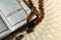 Holy book for muslims,Koran and rosary on wooden engraving background.