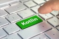 Kotlin computer language. writing on button modern of gray laptop. Finger presses the button. Programmer for work.