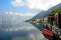 Kotor fjord. Red boat, mountains, clouds. Ancient Perast