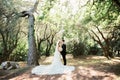 Kotor, Montenegro - 27.06.21: Groom with bride in a white dress and a veil stand in a green park