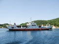 Kotor, Montenegro, June 2011: View of a ferry crossing the Bay of Kotor, loaded with cars, buses and people. Against the backdrop Royalty Free Stock Photo