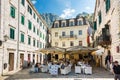 People hide in a shade under restaurant umbrellas in Stari Grad