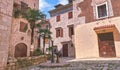 Kotor narrow small streets of historical old town. House drying linen bright sun blind old stone. Authentic structures. No body