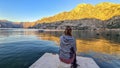 Kotor - Woman sitting at pier with scenic view of Kotor bay at sunrise in summer, Adriatic Mediterranean Sea, Montenegro Royalty Free Stock Photo