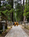 KOYASAN, JAPAN - May 2019: Monks walking on the 2 km long path with ancient tombs in the Okunoin cemetery towards the mausoleum of