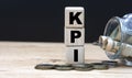 KPI - abbreviation on cubes on the background of a capacity with money Royalty Free Stock Photo