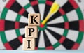 KPI - acronym on wooden cubes on dartboard background