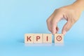 KPI or key performance indicator business target and establishment concept. Human hand stacking wooden blocks