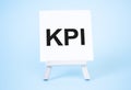 Kpi sign on the white paper. easel on the blue background