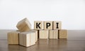 KPI symbol. Concept word `KPI - key perfomance indicator` on cubes on a beautiful wooden table, white background. Business and K