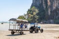 Krabi Province, Thailand - May 12, 2019: A special tractor with a passenger trailer delivers tourists and luggage to the shore