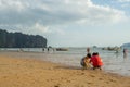 Children playing sand and some people walking and relaxing at Ao Nang beach before the sunset Royalty Free Stock Photo