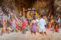 Krabi, Thailand - February 12. 2019: Couple, girl and boy pray fertility goddess for pregnancy in front of the phallus shaped