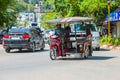 KRABI, THAILAND - 12 May 2016: Tourist shuttle public taxi parked on the public roadway along the beach in Ao Nang town.