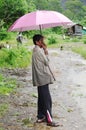 KRABI, THAILAND - OCTOBER 28, 2013: Old asian man under umbrella in rain