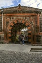 Entrance through an oval portal made of red and black tuff with openwork wrought iron gates to the Museum of Local history in Gyum Royalty Free Stock Photo