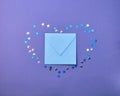 Kraft blue envelope  surrounded by confetti stars in the shape of a heart  on a paper lilac  color background. Mother`s Day, Royalty Free Stock Photo