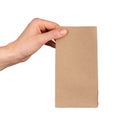 Kraft brown beige bag mockup in hand. Holding paper pouch, isolated on white Royalty Free Stock Photo