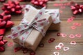 Kraft brown paper gift box with red bows and confetti, on wooden background. Valentine& x27;s Day, Birthday, Party concept Royalty Free Stock Photo