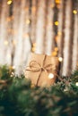 Kraft cardboard gift box tied with rough jute rope on gray wooden background with branches of Christmas tree and Royalty Free Stock Photo