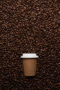 Kraft disposable cup to go, on the background of coffee beans with empty space for text. Royalty Free Stock Photo