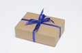 Kraft gift box with blue ribbon is on a white background Royalty Free Stock Photo