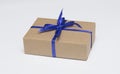 Kraft gift box with blue ribbon is on a white background Royalty Free Stock Photo