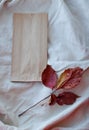 Kraft paper bags with autumn leaves on vintage linen fabric background