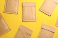 Kraft paper envelopes on yellow background, flat lay